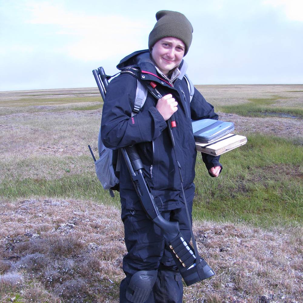 Ashley holds her equipment and smiles at the camera.